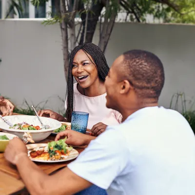 A Family Gathers Around a Outdoor Table to Enjoy a Meal.