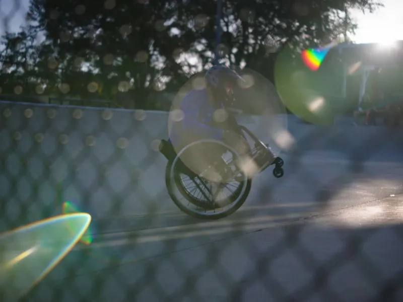 Man in a wheelchair doing a wheelie
